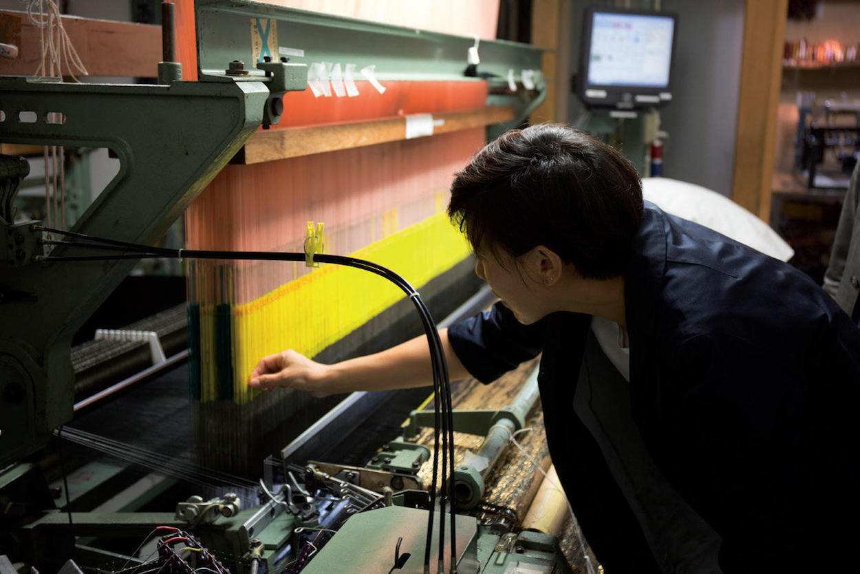 MOON Kyungwon examines the loom at the Hosoo studio.